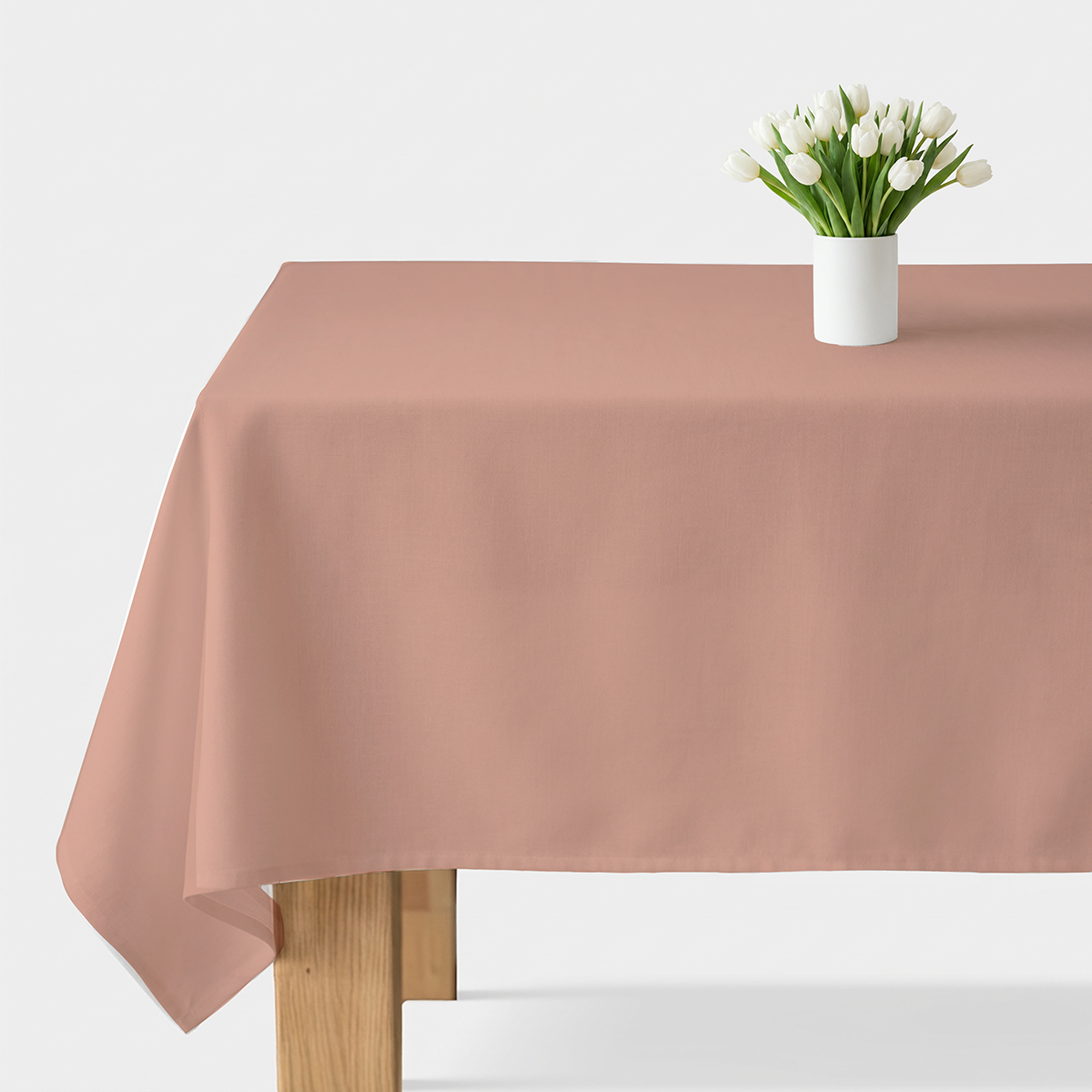 gładki różowy obrus na stole z wazonem białych tulipanów