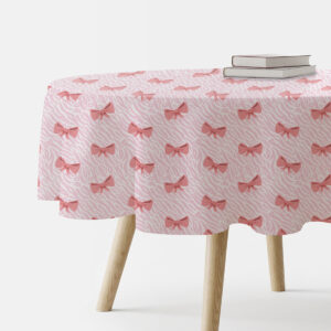 okrągły obrus z nadrukiem różowych kokardek widok z boku z książkami na stole