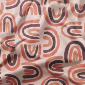 Zbliżenie tkaniny ukazujące ręcznie malowany wzór łuków i delikatną fakturę materiału