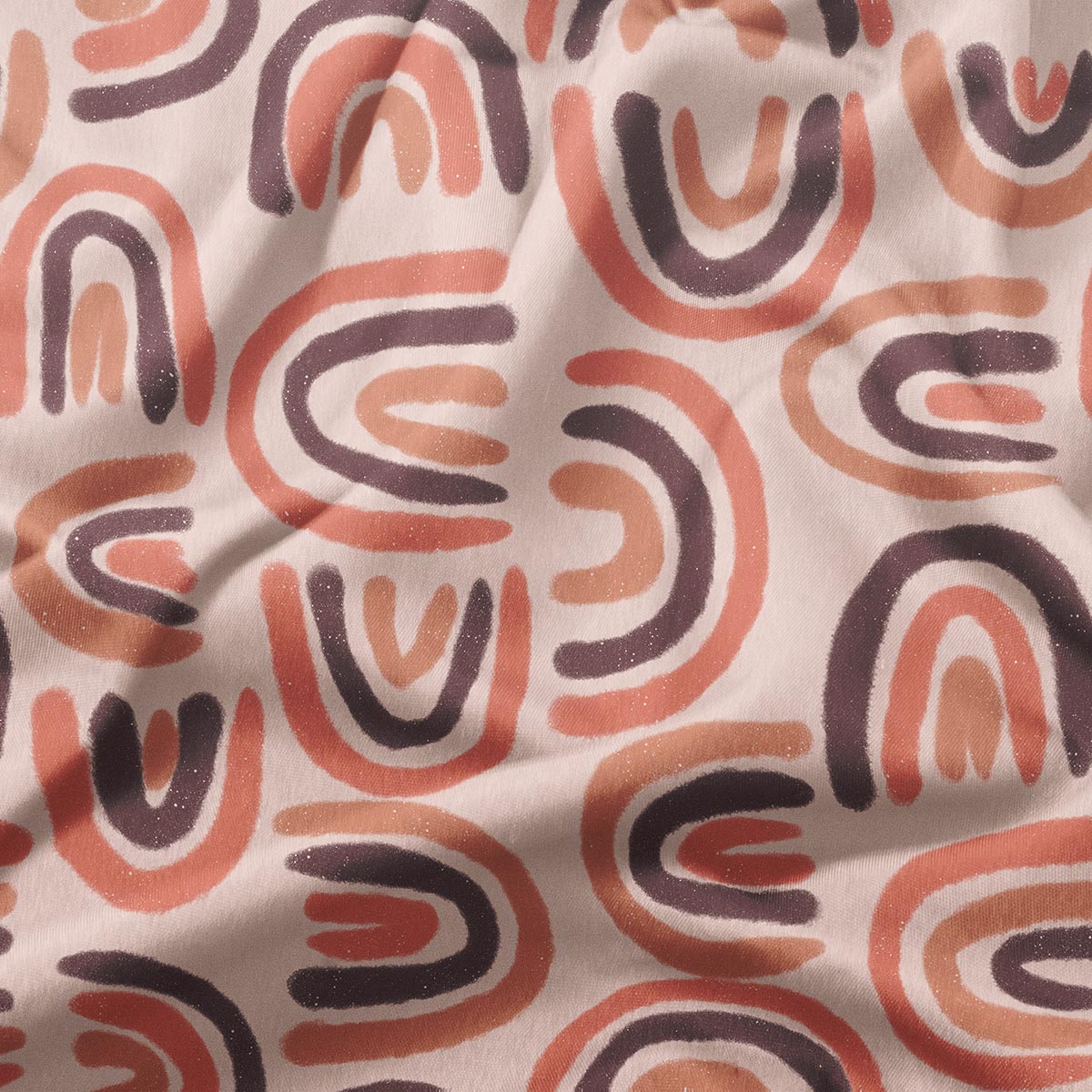 Zbliżenie tkaniny ukazujące ręcznie malowany wzór łuków i delikatną fakturę materiału