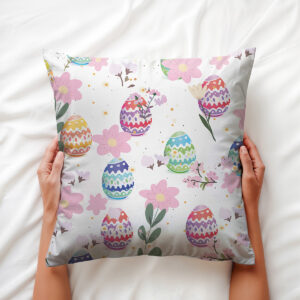 Ręce trzymające poduszkę z motywem pisanek i delikatnych kwiatów, ujęcie aranżacyjne