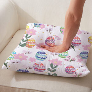 Ujęcie detalu pokazujące miękkość i dotyk poduszki z nadrukiem pisanek, ręka naciska materiał