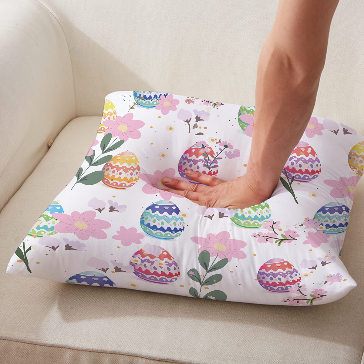 Ujęcie detalu pokazujące miękkość i dotyk poduszki z nadrukiem pisanek, ręka naciska materiał