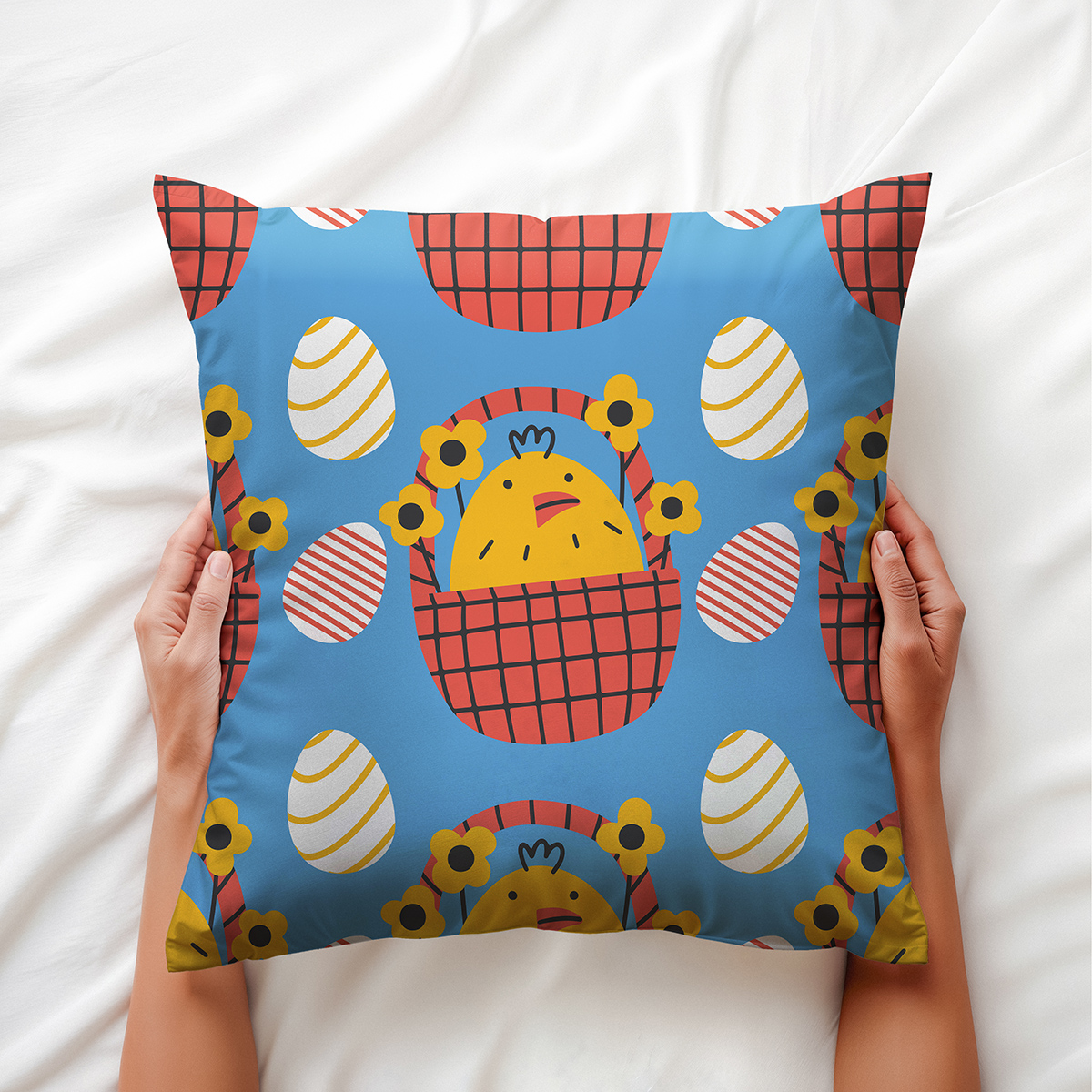 Osoba trzyma poduszkę z motywem kurczaczków w koszykach, detale wzoru widoczne z bliska