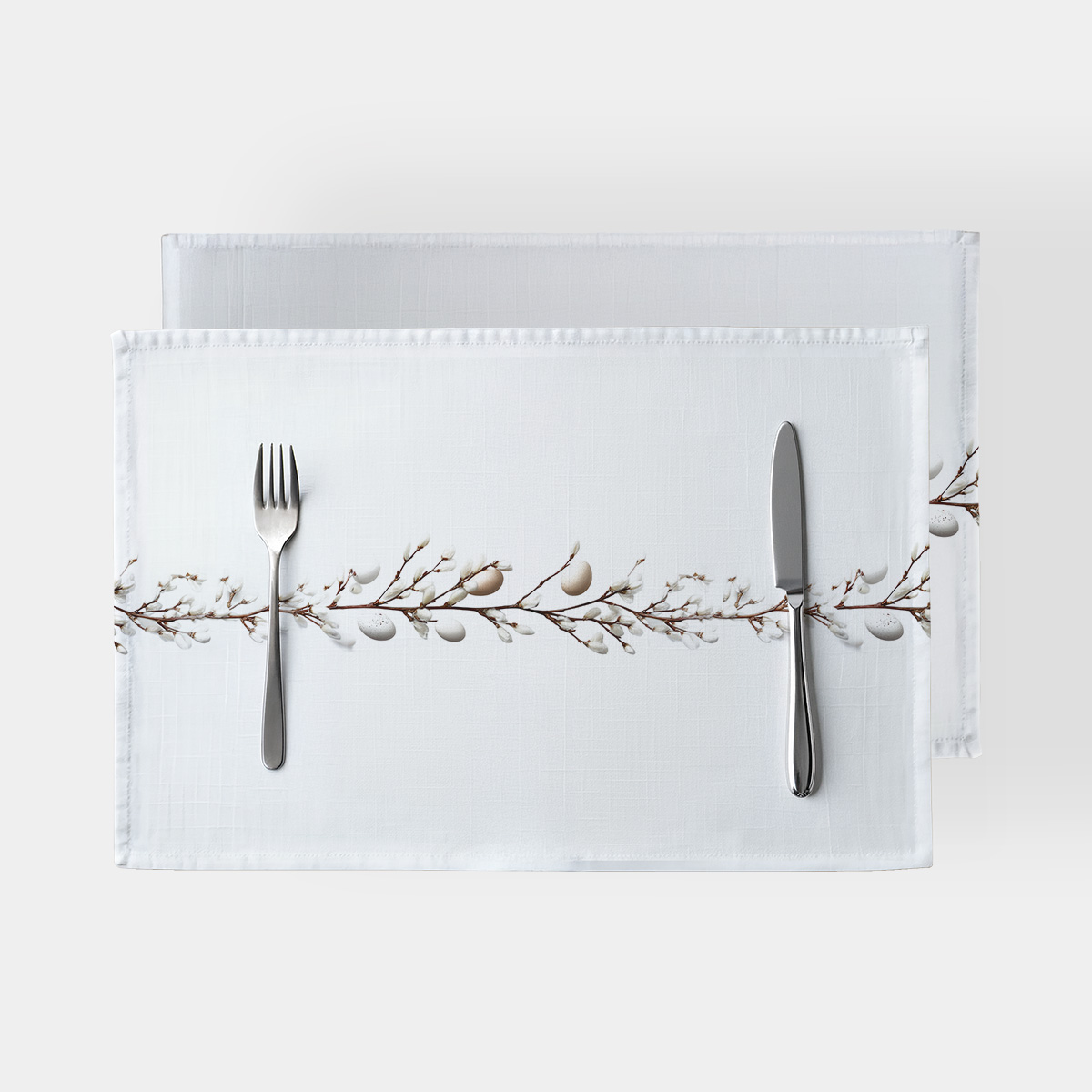 biała podkładka stołowa z poziomym motywem bazi i delikatnymi pisankami, ujęcie z góry