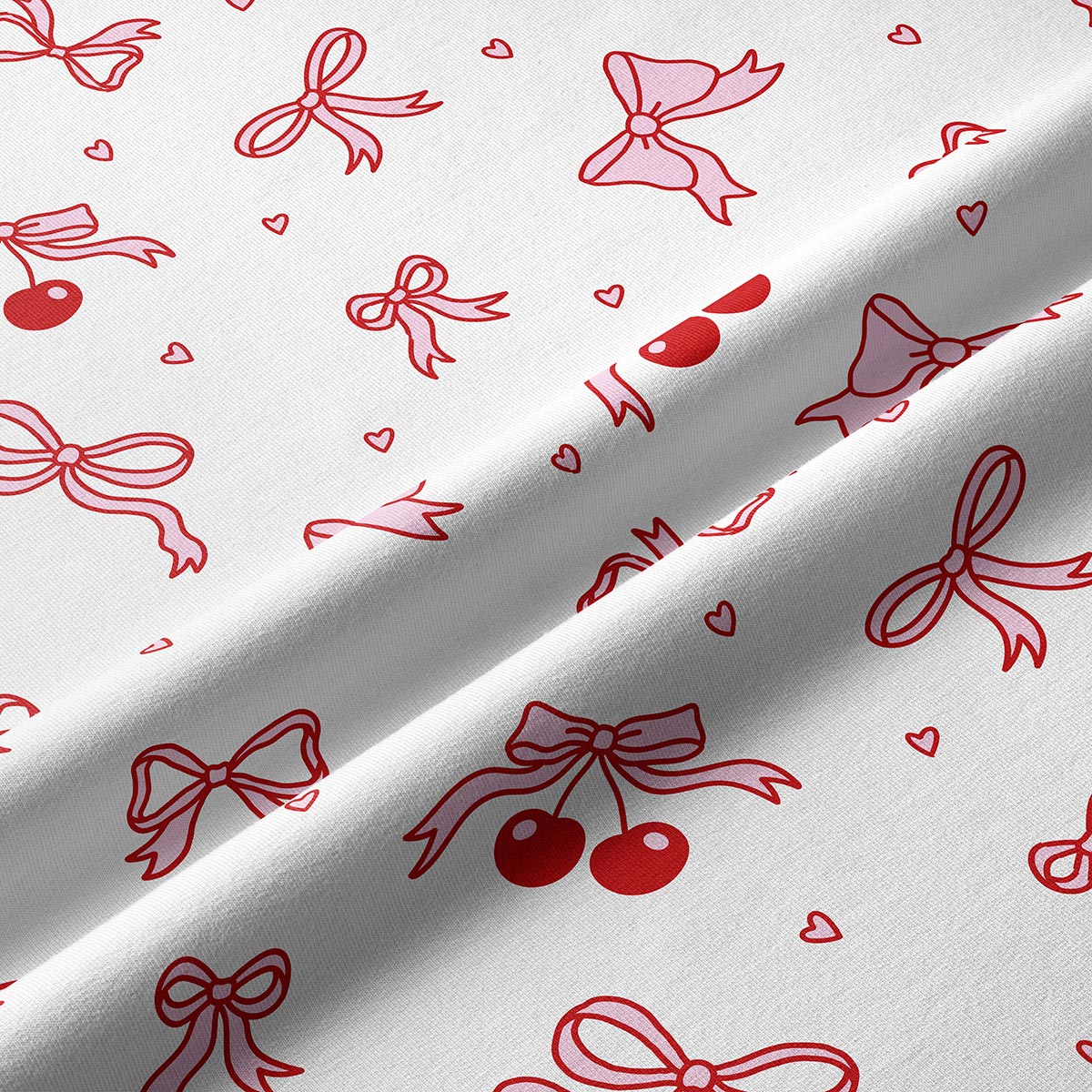 Zbliżenie na nadruk kokardek i par wisienek na białym tle, detal tkaniny