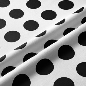 Zbliżenie tkaniny z dużymi czarnymi kropkami, widoczna struktura materiału
