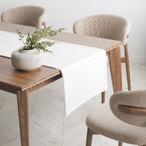 Bieżnik rozłożony na jadalnianym stole z wazą i krzesłami w tle