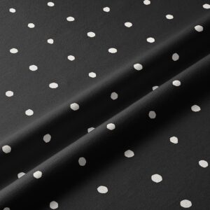 Zbliżenie na tkaninę z nieregularnymi białymi kropkami na czarnym tle