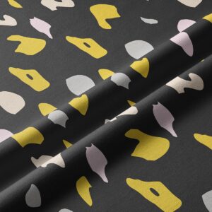 Zbliżenie na tkaninę i nieregularne plamy w odcieniach musztardowym, pudrowym i beżowym