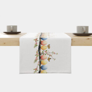 Bieżnik rozłożony na stole z rzędem pastelowych pisanek na gałązce i kwitnącymi różowymi kwiatami