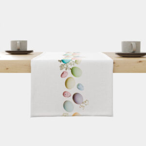 Bieżnik ze świątecznym motywem pastelowych pisanek i delikatnych gałązek ułożony na jasnym drewnianym stole