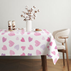 stół udekorowany talerzami i naczyniami na obrusie z motywem serc, widok z boku