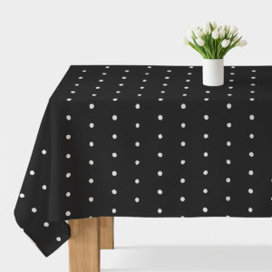 czarny obrus z nieregularnymi białymi groszkami na stole z wazonem białych tulipanów