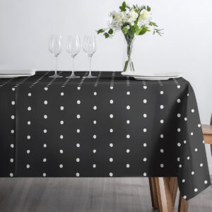 czarny obrus w białe kropki udekorowany kieliszkami i talerzami