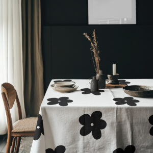 aranżacja stołu z dekoracjami i naczyniami na obrusie w duże czarne kwiaty