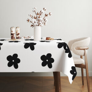 jasne wnętrze z drewnianym krzesłem i stołem przykrytym obrusie z graficznymi kwiatami