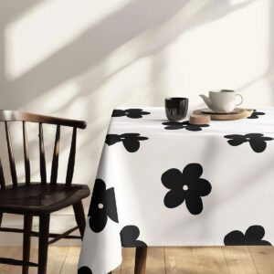 detal narożnika obrusu pokazujący kontrastowy, graficzny kwiatowy wzór przy krześle