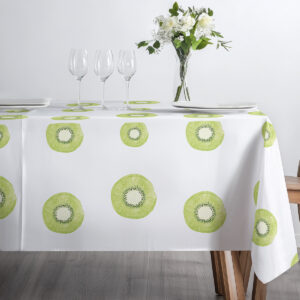 Zestaw naczyń i kieliszków na obrusie z wzorem zielonych plasterków kiwi