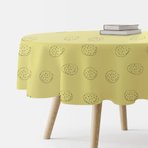 okrągły żółty obrus z ręcznie rysowanymi okręgami na stole z książkami