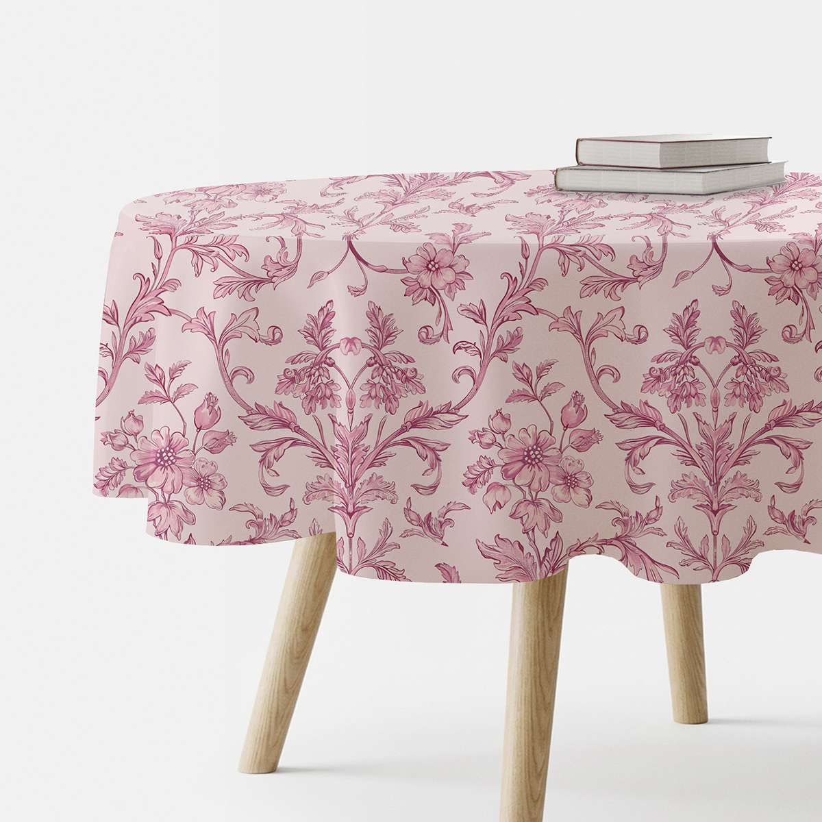 okrągły obrus z różowym ornamentem kwiatowym na stole z książkami