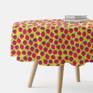 okrągły obrus z motywem czerwonych truskawek na żółtym tle na stole