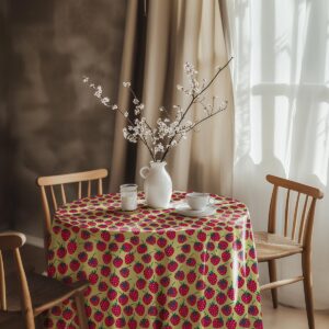 aranżacja stołu z wazonem i filiżanką na okrągłym obrusie w truskawki