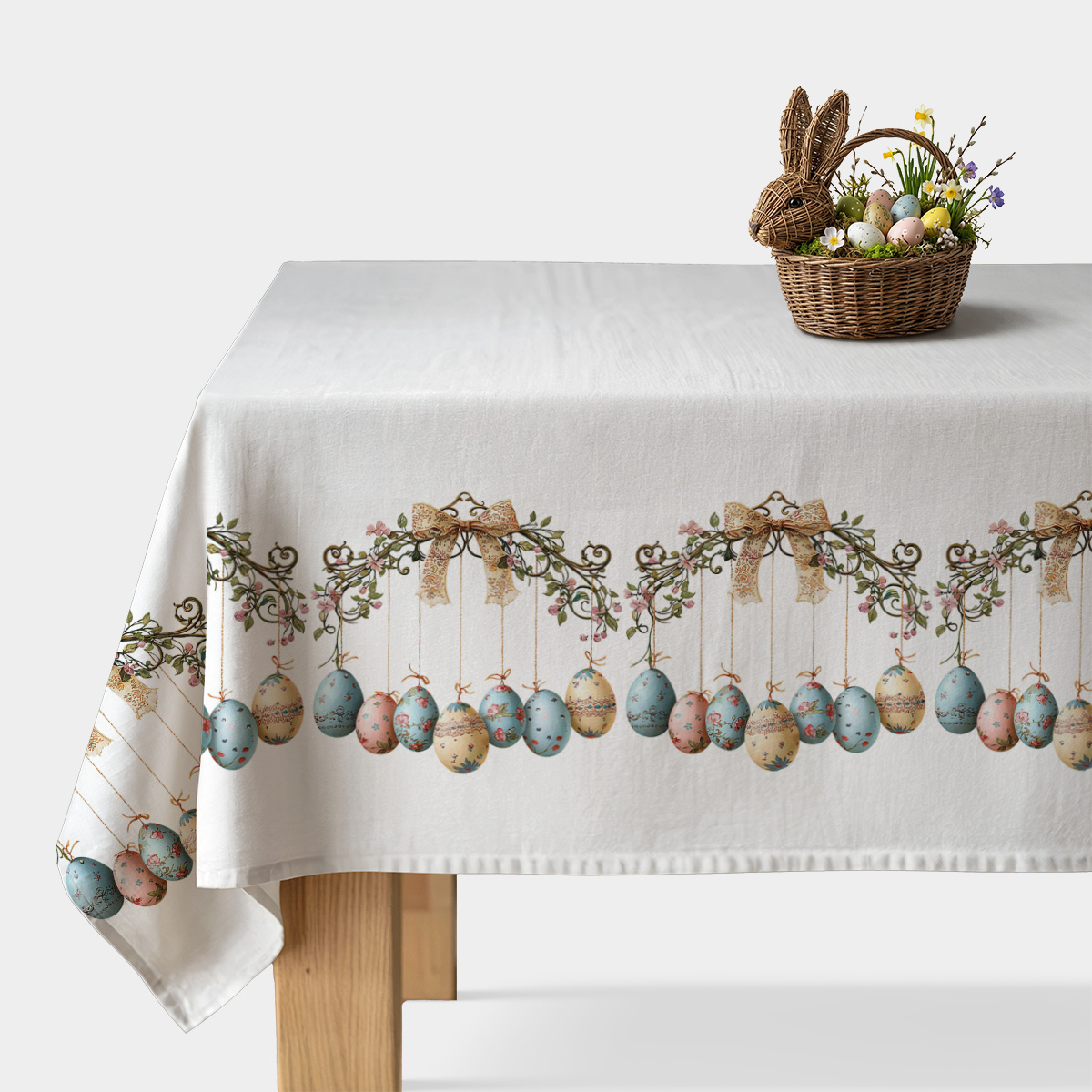 biały obrus z dekoracyjnym brzegiem wiszących pastelowych pisanek i ozdobnych wstążek