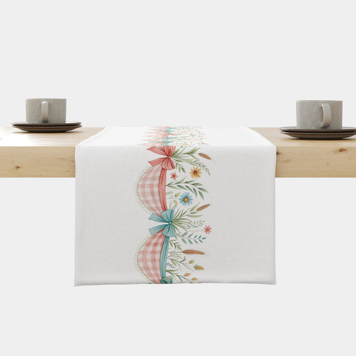 Świąteczny biały bieżnik z kokardami i polnymi kwiatami na jasnym drewnianym stole, widok centralny