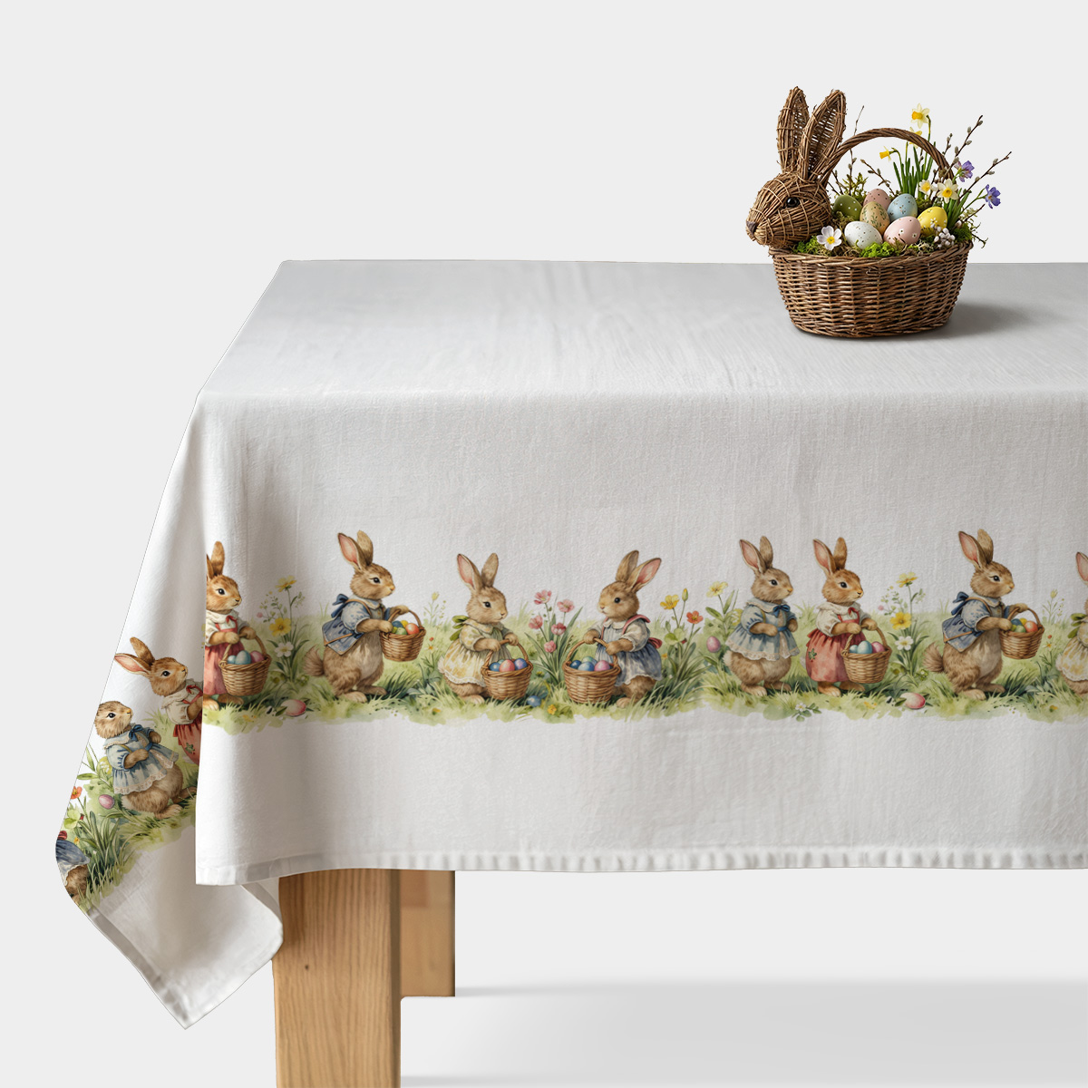 Główny widok obrusa z rzędem króliczków niosących koszyczki z pisankami na białym tle