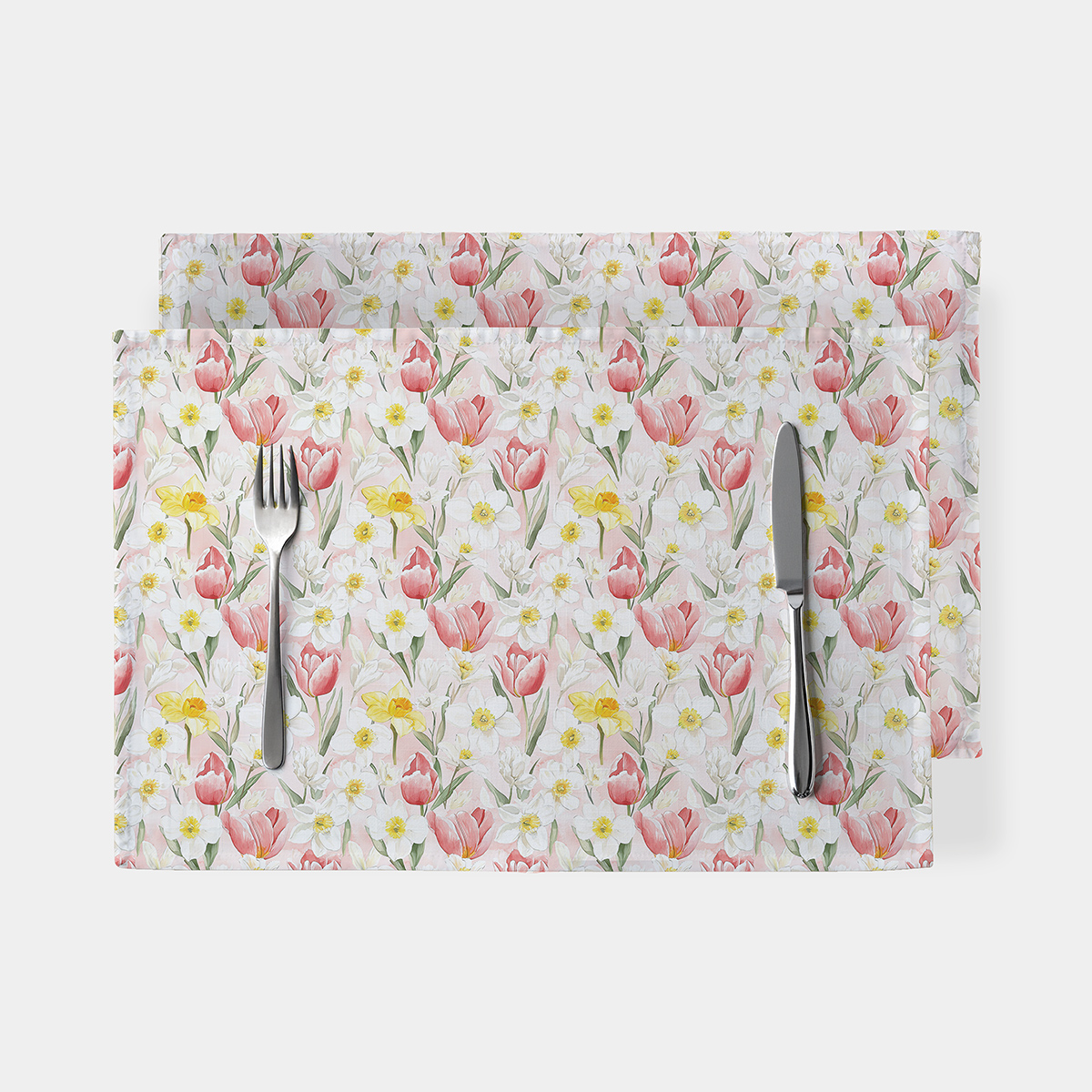 podkładki stołowe z pastelowym wzorem tulipanów i żonkili ułożone na białym tle z widocznymi sztućcami