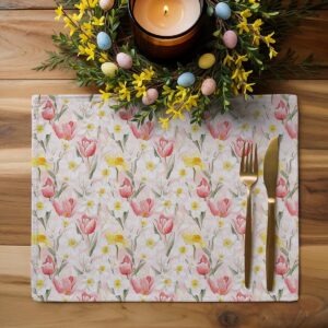 aranżacja stołu z podkładką, wieńcem z pisankami i zapaloną świecą tworząca wielkanocną dekorację