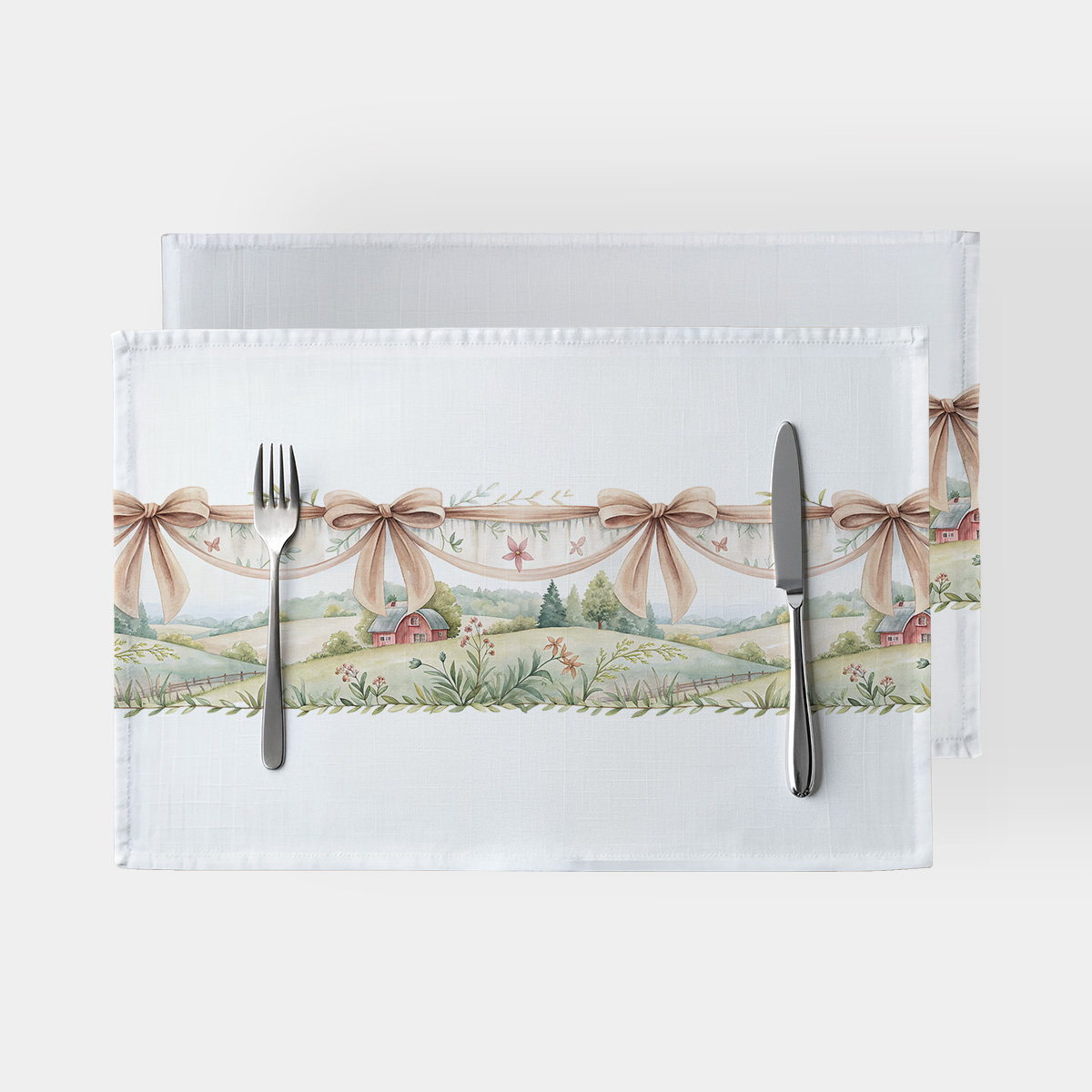 Para podkładek na białym tle z delikatnym pastelowym pejzażem i dekoracyjnymi beżowymi wstążkami, zastawione sztućcami