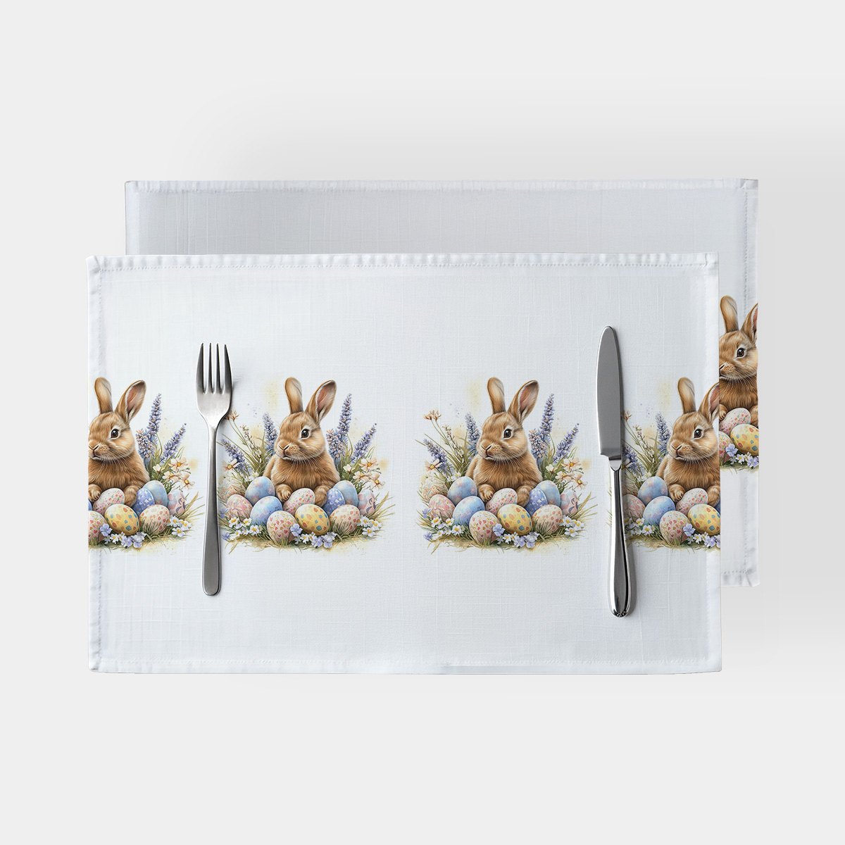 Podkładki na stole z wzorem zająca i pastelowymi pisankami widok z góry
