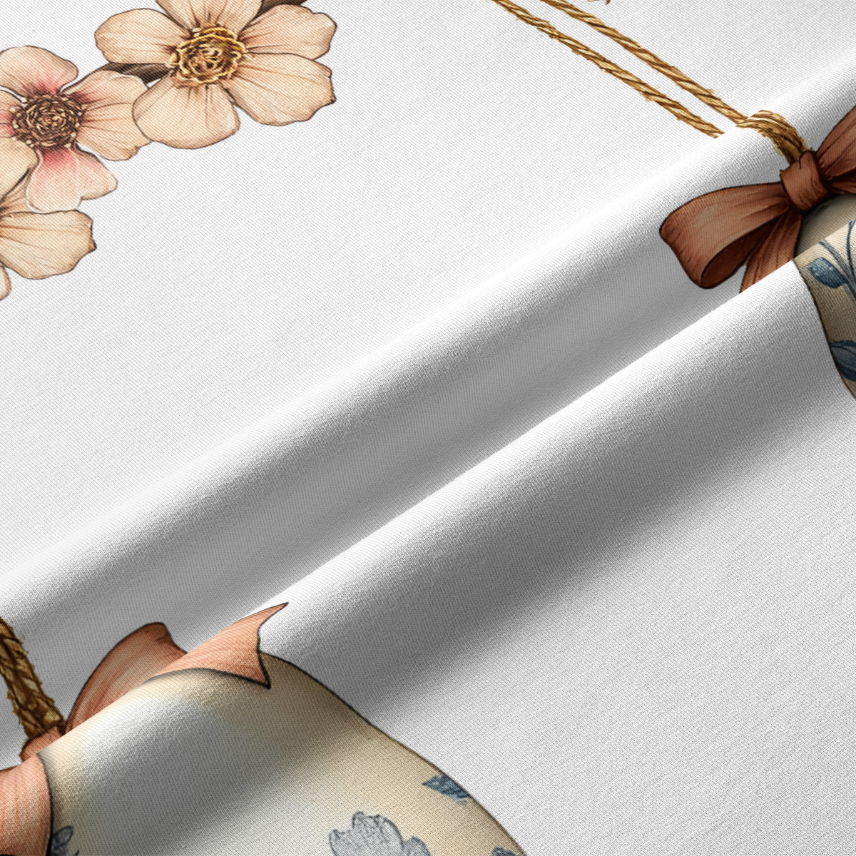 Zbliżenie na tkaninę i detal nadruku: kokardka, kwiaty i ozdobne jajko