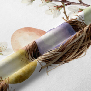 Zbliżenie na fakturę tkaniny i detal gniazda z pastelowymi pisankami oraz kwitnącą gałązką