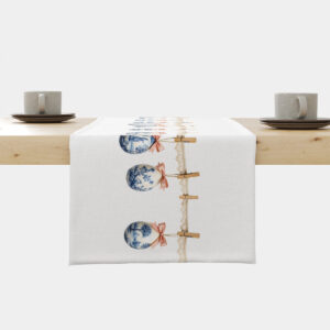 biały bieżnik z nadrukiem wiszących malowanych pisanek na koronkowym sznurku ułożony na drewnianym stole