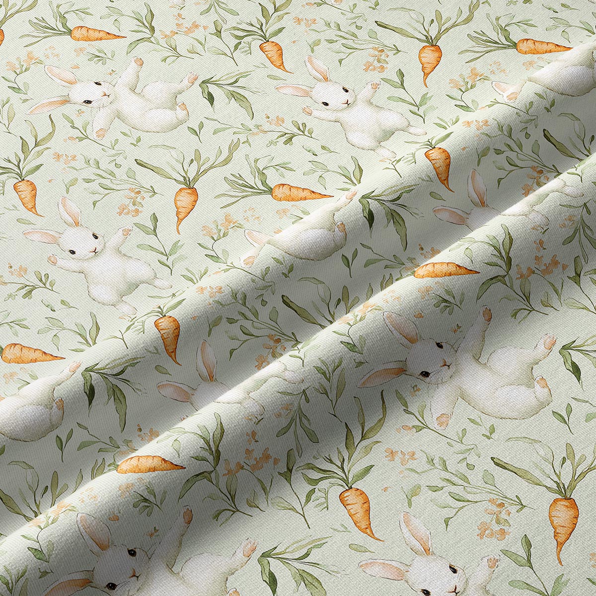 Zbliżenie na fakturę tkaniny i akwarelowe detale króliczków oraz marchewek