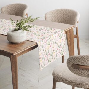 Widok boczny bieżnika na drewnianym stole z powtarzającym się wzorem pisanek