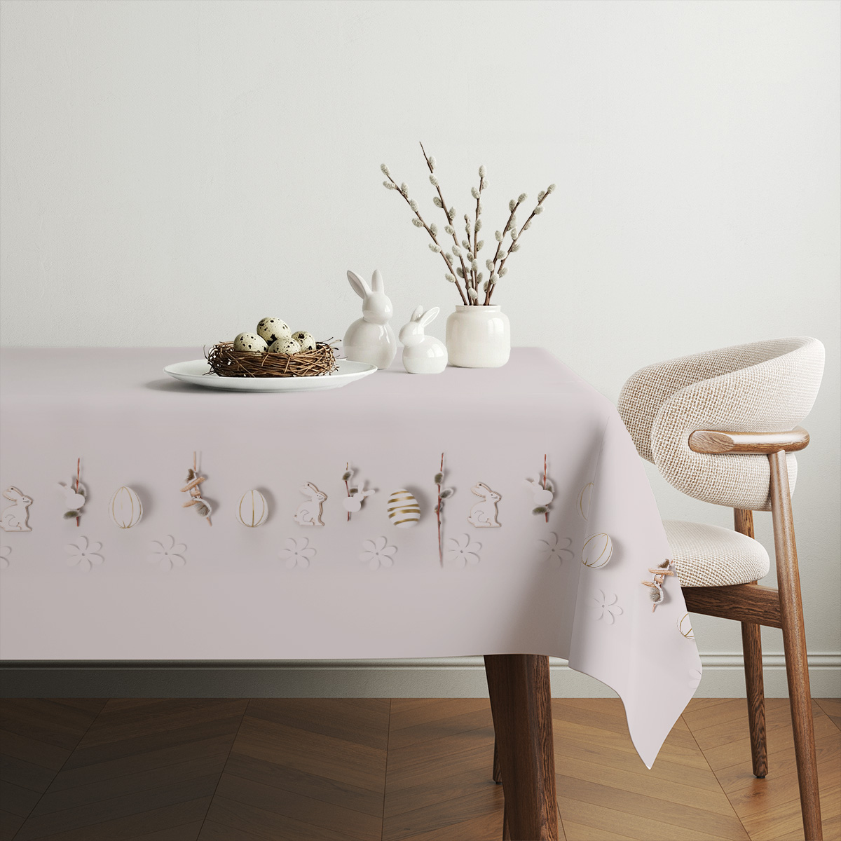 Aranżacja świątecznego stołu z obrusem, ceramicznymi zajączkami i gałązkami wierzbiny