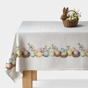 Obrus z motywem pastelowych pisanek i kwitnących gałązek rozłożony na stole, widoczny rząd kolorowych pisanek