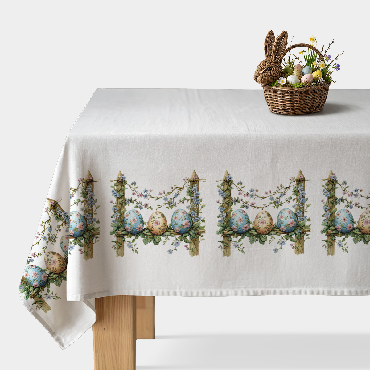 główny widok białego obrusu z motywem malowanych pisanek na plecionym płotku