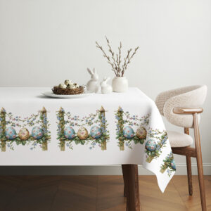 aranżacja stołu z obrusem, koszyczkiem z jajkami i wiosennymi dekoracjami