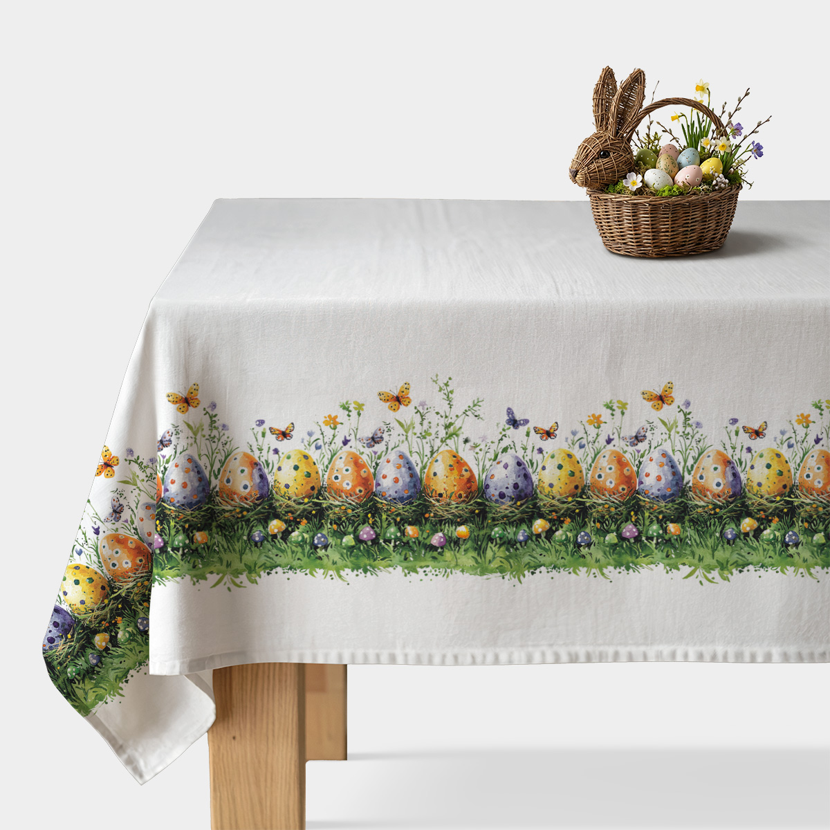 Obrus z malowanymi pisankami i motylami rozłożony na stole, widok całości