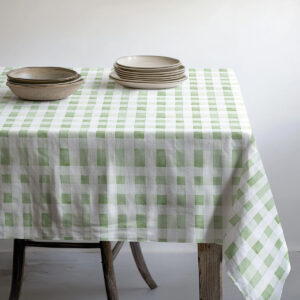 stół nakryty kratkowanym obrusem z ułożonymi talerzami i miseczkami