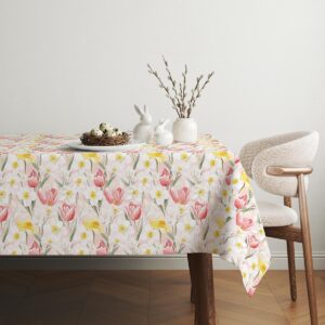 Aranżacja stołu z ozdobami wielkanocnymi: ceramiczne zajączki i gałązki kotków na obrusie