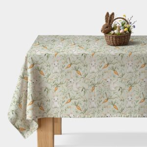 Obrus z akwarelowymi zajączkami i marchewkami rozłożony na stole, główne ujęcie produktu