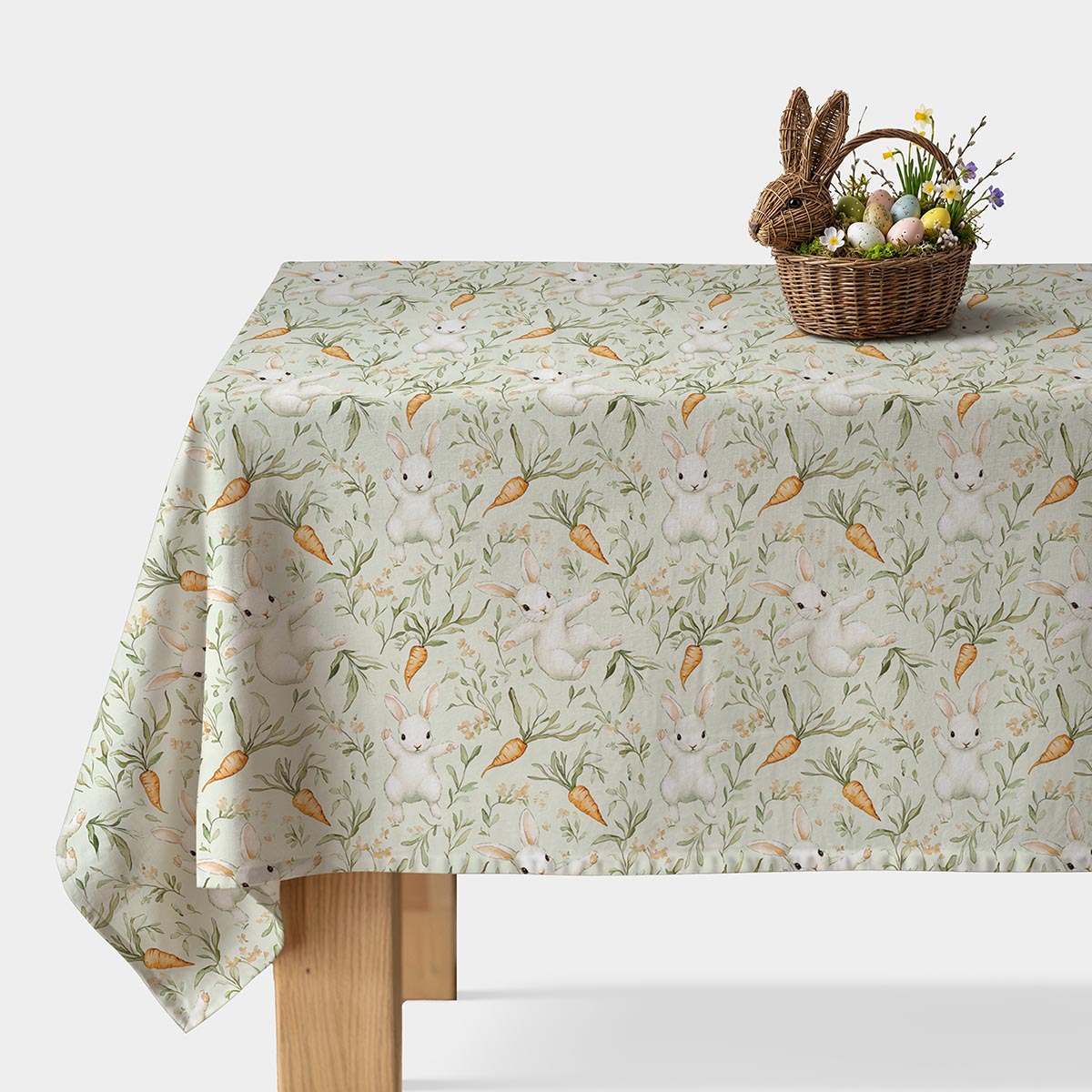 Obrus z akwarelowymi zajączkami i marchewkami rozłożony na stole, główne ujęcie produktu
