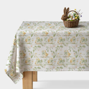 obrus z motywem kurczaczków rozłożony na stole z koszykiem wielkanocnym i pisankami