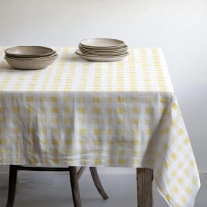 stół nakryty obrusem z porcjami talerzy i naturalnymi misami